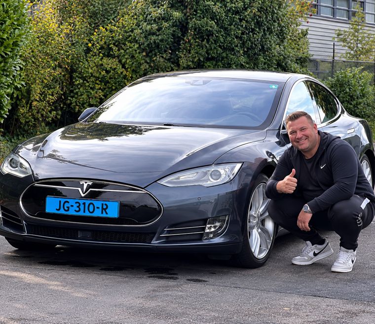 Chauffeur bij een Tesla Model S van Topland Vervoer
