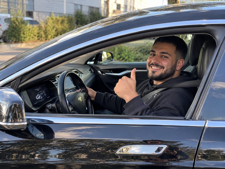 Chauffeur bij een Tesla Model S van Topland Vervoer