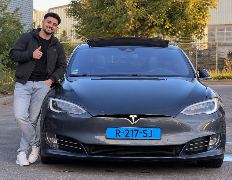 Chauffeur bij een Tesla Model S van Topland Vervoer