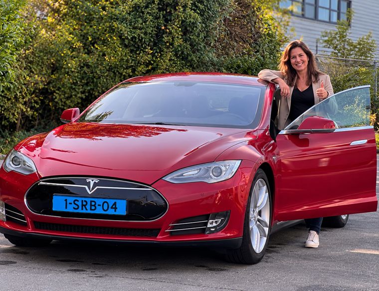 Chauffeur bij een Tesla Model S van Topland Vervoer