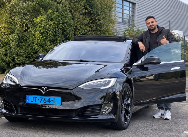Chauffeur bij een Tesla Model S van Topland Vervoer